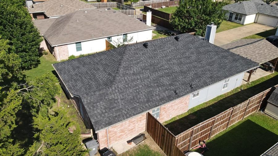 Aerial view of a completed roof replacement with new grey architectural shingles