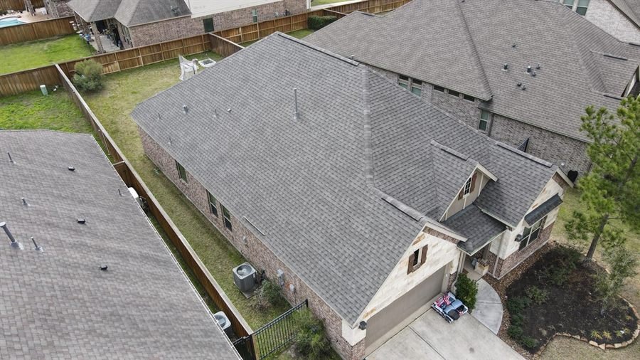 Aerial view of a finished roof on a large brick and stone home